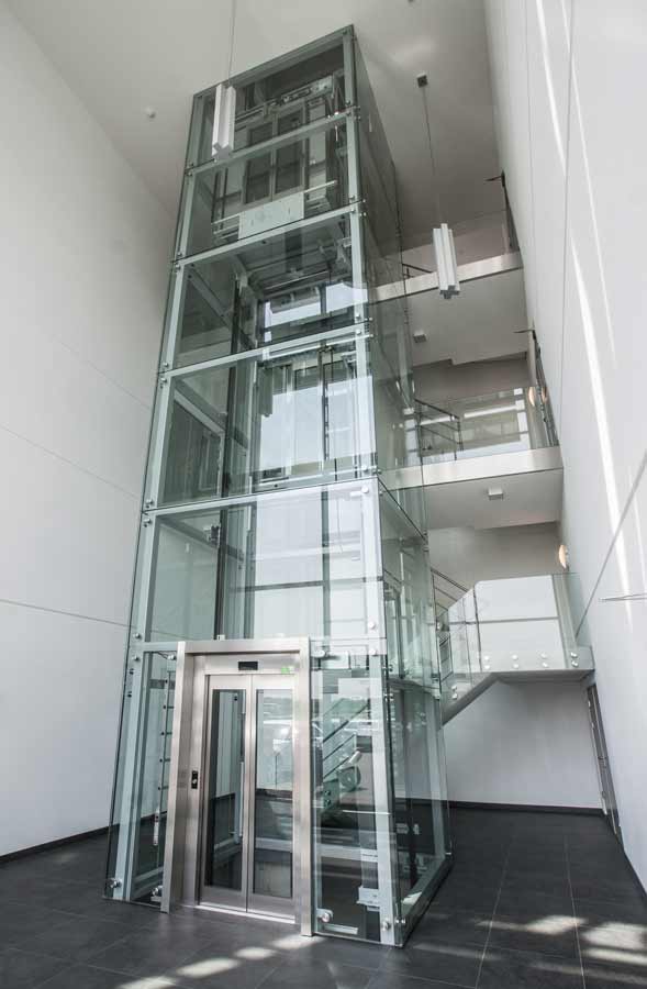 Glazen liftinstallatie in een gebouw met meerdere verdiepingen